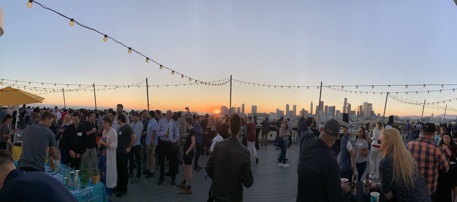 A rooftop mixer at sunset over downtown Los Angeles